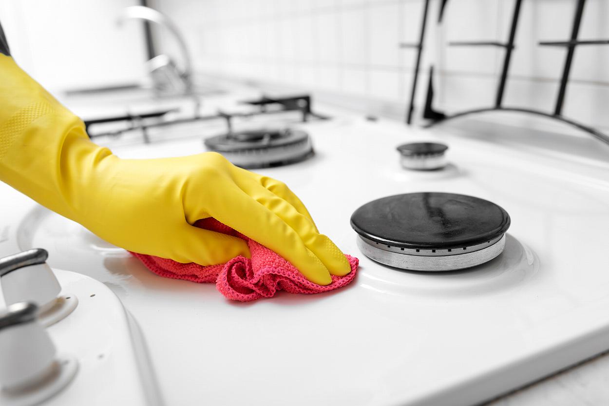 Gloved hand wiping stovetop